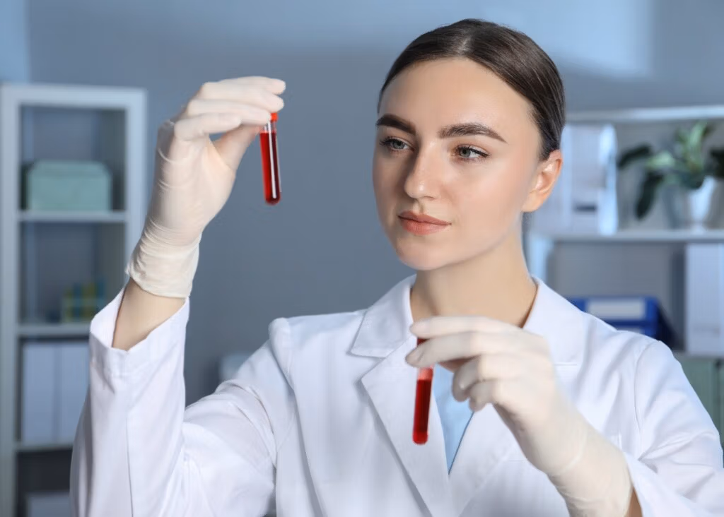 scientist examining red liquid in test tubes