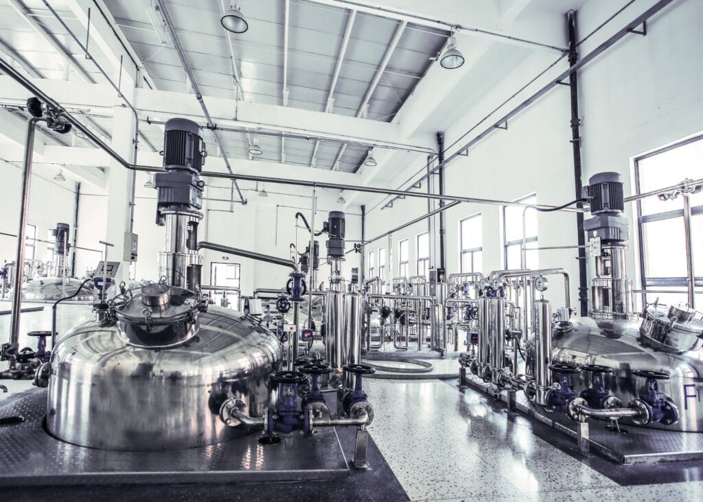 gleaming stainless-steel fermenters inside a bright plant