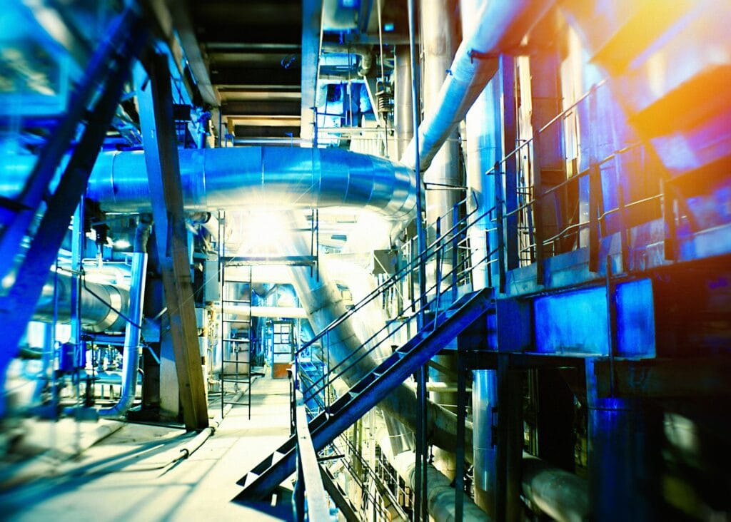 inside a maze of pipes, catwalks, bright blue lighting
